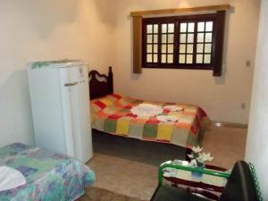 a room with two beds and a refrigerator and a window at Cháles Terra Nativa in Monte Verde +64 photos