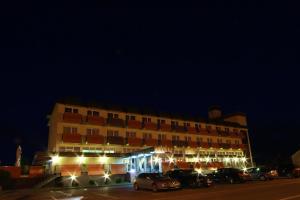 een gebouw waar 's nachts auto's voor geparkeerd staan bij Hotel Garić in Garešnica