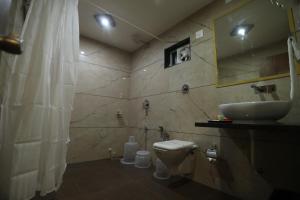 a bathroom with a sink and a toilet at HOTEL neptune inn in Amreli