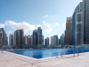 a swimming pool on top of a city skyline at Frank Porter - Cayan Tower in Dubai