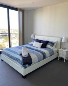 een slaapkamer met een groot bed met blauwe en witte lakens bij LOCATION LOCATION CITY VIEWS NETFLIX WIFI WINE in Perth