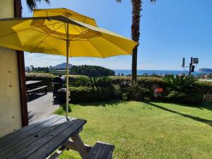 a yellow umbrella sitting on top of a wooden bench at Beewool Chaewool Pension in Seogwipo