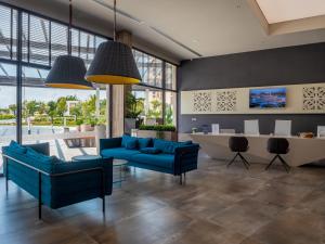 een woonkamer met blauwe meubels en grote ramen bij Aqua Paradise Resort & Aqua Park in Nesebar