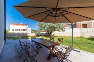 a table and chairs with an umbrella on a patio at Apartment Lino in Premantura
