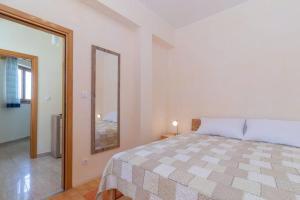 a bedroom with a large bed and a mirror at Apartment Lino in Premantura
