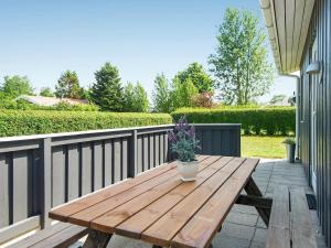 une table en bois sur un balcon avec une plante en pot dans l'établissement 6 person holiday home in Haderslev, à Diernæs