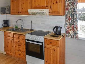 cocina con armarios de madera y horno con fogones en Holiday home Aukra III, en Aukra