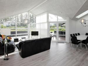 sala de estar con sofá negro y mesa en 10 person holiday home in L kken, en Løkken
