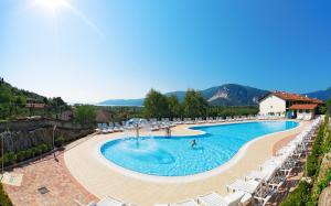 einen Pool mit Stühlen und Menschen in einem Resort in der Unterkunft Residence Isolino in Verbania