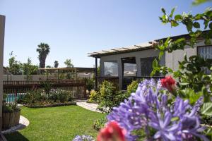 a garden with purple flowers and a house at Princess Holiday Home in Cape Town