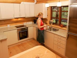 uma mulher numa cozinha com um lavatório em 10 person holiday home in Hadsund em Odde