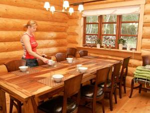 uma mulher de pé numa mesa de madeira numa cabana em 10 person holiday home in Hadsund em Odde
