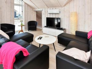 un soggiorno con mobili in pelle nera e TV a schermo piatto di 10 person holiday home in Ansager ad Ansager