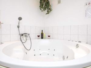 Hals的住宿－8 person holiday home in Hals，带淋浴的浴缸以及一瓶葡萄酒。