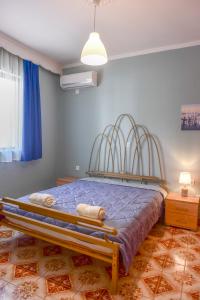 a bedroom with a bed with blue walls and a fan at villa62rodos in Kremasti