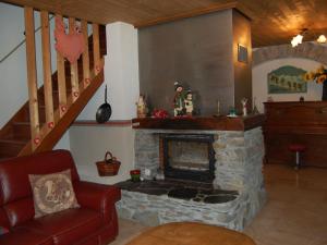 a living room with a fireplace and a staircase at Magnificent chalet with sauna in Le Villard