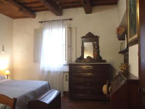 a bedroom with a dresser with a mirror and a window at Pisa Stay close to Leaning Tower in Pisa