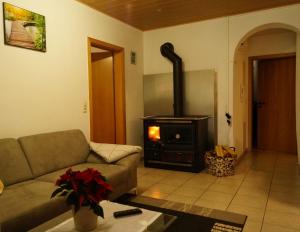 ein Wohnzimmer mit einem Sofa und einem Holzofen in der Unterkunft Urbach 19 in Bad Waldsee