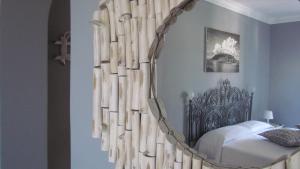 een slaapkamer met een bed met een grote ronde spiegel bij B&B Il Cappero in Lipari