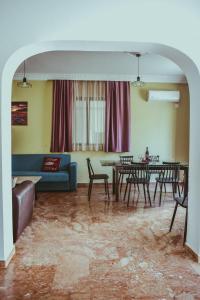 uma sala de estar com um sofá, mesas e cadeiras em villa62rodos em Kremasti