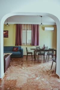 a living room with a couch and tables and chairs at villa62rodos in Kremasti +7 photos