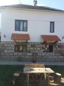 a wooden picnic table in front of a building at VILA BOJANA in Inovo