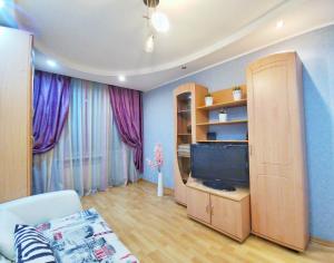 ヤロスラヴリにあるApart-Comfort Yangshuoのリビングルーム(テレビ、紫のカーテン付)