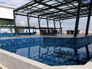 a swimming pool with a pergola and a table at Traveler's homestay 旅人窝@ The Venus Sitiawan in Kampong Lumut Kiri