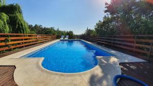 una piscina en la parte superior de una terraza de madera en Brisas del Lago Tandil en Tandil
