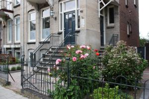 een huis met een hek met bloemen ervoor bij Arnhem Studios in Arnhem