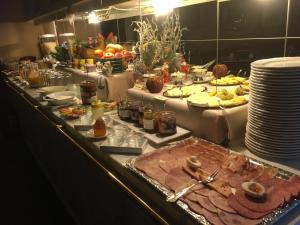 a buffet line with food and plates of food at Hotel-Pension Lydia in Berlin