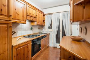 een keuken met houten kasten en een fornuis met oven bij Villa Radiosa - Stayincortina in Cortina dʼAmpezzo