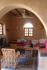 a living room with a table and chairs in a room at Desert Rose Guesthouse in Luxor