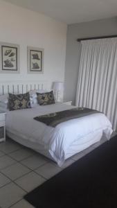 1 dormitorio con 1 cama blanca grande y ventana en Casa Do Mar Guest House, en Praia do Tofo