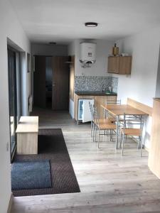 Una cocina y un comedor con mesa y sillas. en Orion Apartments (family), en Lunca de Sus