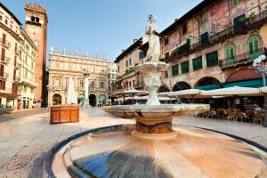 a fountain in the middle of a street with buildings at Casa Giulietta in Verona