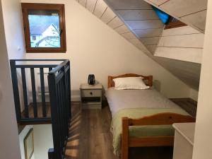 a small bedroom with a bed and a staircase at Chez Albert in Aiguebelette-le-Lac