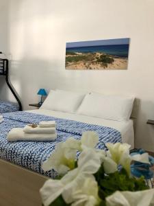 Una habitación de hotel con una cama con toallas y flores en B&B Vento del Mare, en San Pietro in Bevagna