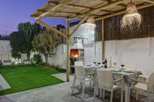 een patio met een tafel en stoelen en een open haard bij Villa Isabel By Seric, 15' walking to the beach in Torremolinos