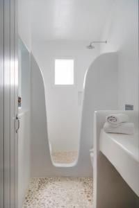 La salle de bains blanche est pourvue d'un lavabo et de toilettes. dans l'établissement Zefi Hotel & Suites, à Náoussa