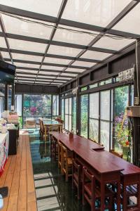 a dining room with a large wooden table and windows at PULI GuanPu Fallsview Stay House in Puli
