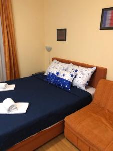 ein Bett mit blauer Bettwäsche und einem Stuhl in einem Zimmer in der Unterkunft Studio Mišel in Vrnjačka Banja
