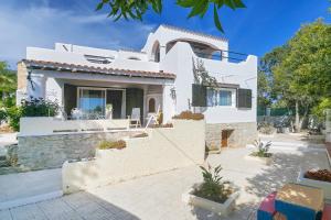 a white villa with a staircase in front of it at Can Ben Parit in San Antonio