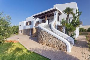 a villa with a staircase in front of a house at Huerta in San Antonio