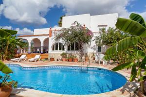 a villa with a swimming pool in front of a house at Can Ramos in Ses Fontanelles