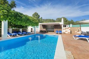 ein Pool mit blauen Stühlen und ein Haus in der Unterkunft Can Ben Parit in Sant Antoni de Portmany