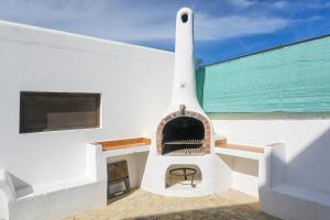 a white building with a fireplace in front of the ocean at Can Ben Parit in San Antonio