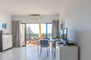 a living room with a table with a computer and a balcony at Modern Top Floor Apartment 60m2 - Balcony with Pool & Sea View - Vilamoura in Vilamoura