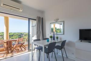 a dining room with a table and chairs and a balcony at Modern Top Floor Apartment 60m2 - Balcony with Pool & Sea View - Vilamoura in Vilamoura