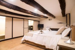 a bedroom with a large white bed and a lamp at Casa Napoletana - Spaccanapoli in Naples